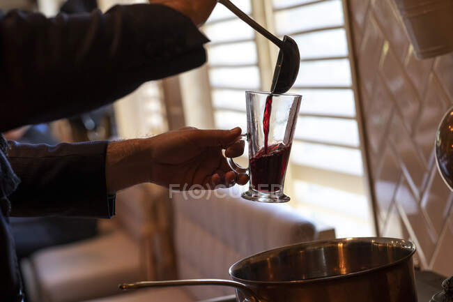 Junge serviert ein Glas Glühwein — Stockfoto