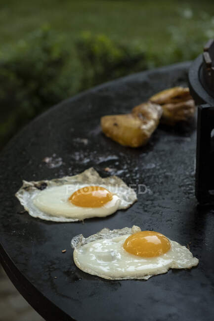Close-up de ovos fritos e carne em um churrasco ao ar livre — Fotografia de Stock