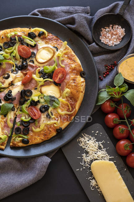 Primo piano di una pizza di prosciutto, pomodoro, oliva, peperoni e cipolla — Foto stock