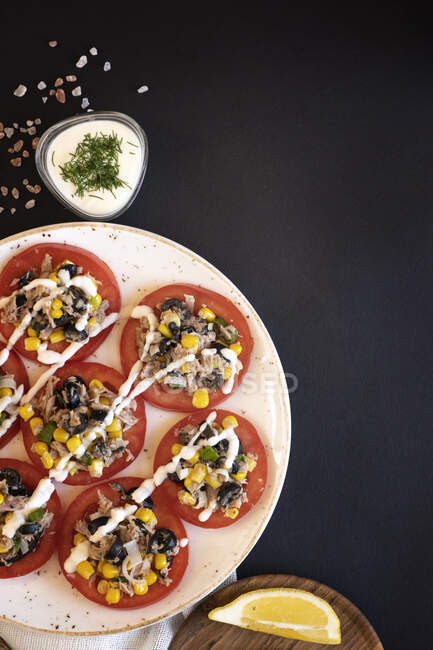 Tomato with tuna, sweetcorn, olive and mayonnaise — Stock Photo