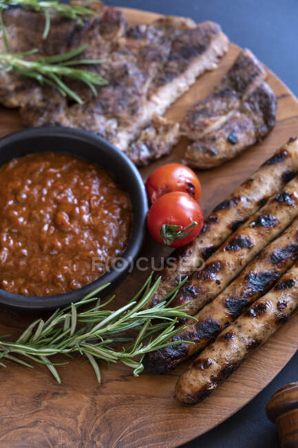 Стейк-гриль и колбаса с томатным соусом — стоковое фото