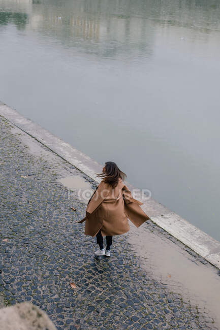 Mujer caminando por la orilla del río, Roma, Lazio, Italia - foto de stock