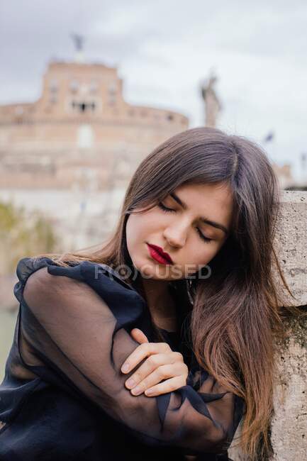 Retrato de una mujer apoyada en una pared, Roma, Lazio, Italia - foto de stock