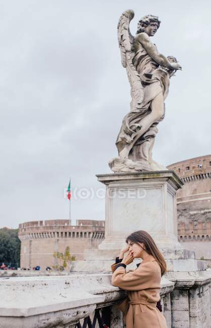 Mujer de pie frente a Castel Sant 'Angelo, Mausoleumn de Adriano, Roma, Lazio, Italia - foto de stock