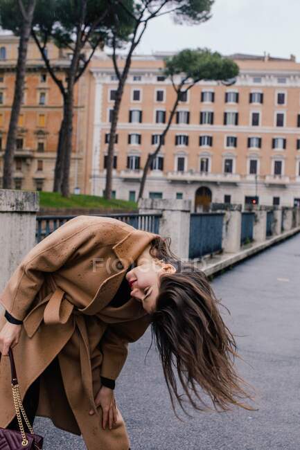 Woman standing in the street tossing her hair, Rome, Lazio, Italy — Stock Photo