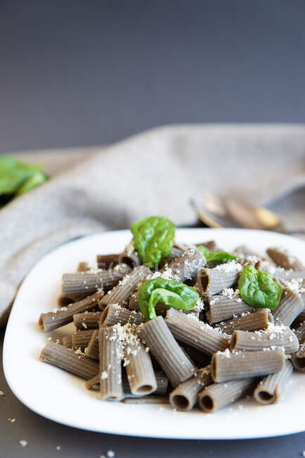 Lentil rigatoni pasta with spinach and parmesan — Stock Photo