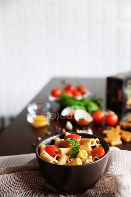 Bowl of rigatoni pasta with basil and tomato — Stock Photo