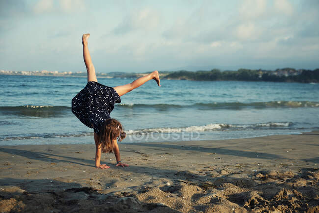 Девушка делает стойку на руках на пляже, Болгария — стоковое фото