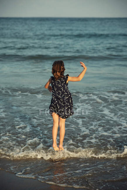 Visão traseira de uma garota andando no surf oceânico, Bulgária — Fotografia de Stock