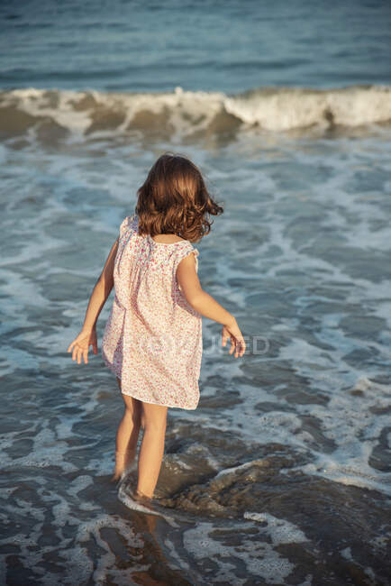 Rear view of a girl walking in the ocean surf, Bulgaria — Stock Photo