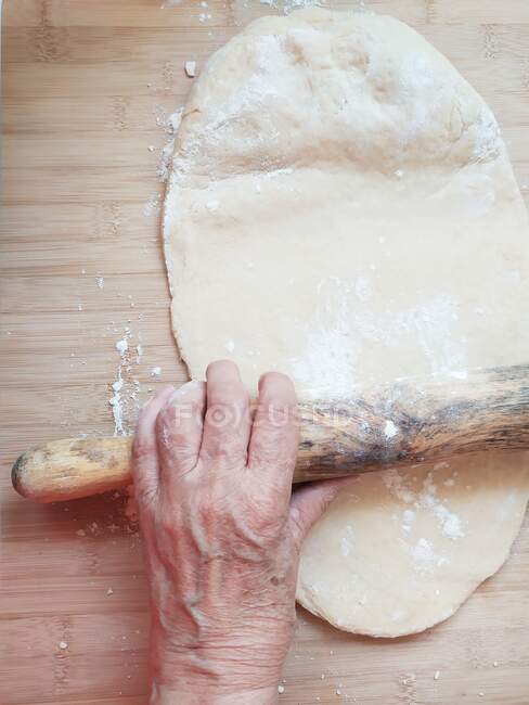 Femme âgée déroulant la pâte — Photo de stock