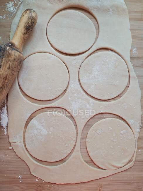 Домашнее тесто и скалка на деревянном столе — стоковое фото