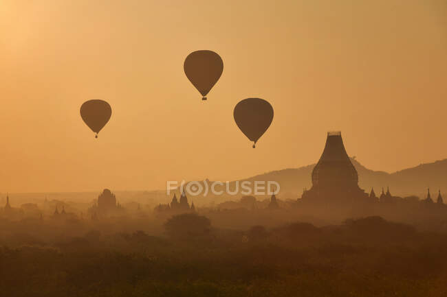 Globos de aire caliente volando sobre Bagan al amanecer, Mandalay, Myanmar - foto de stock