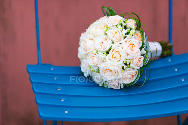 Primer plano de un ramo de boda en una silla - foto de stock