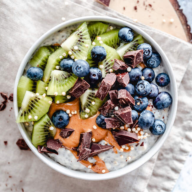 Chia-Pudding-Schüssel mit Kiwi-Früchten, Blaubeeren, Erdnussbutter und Schokolade — Stockfoto