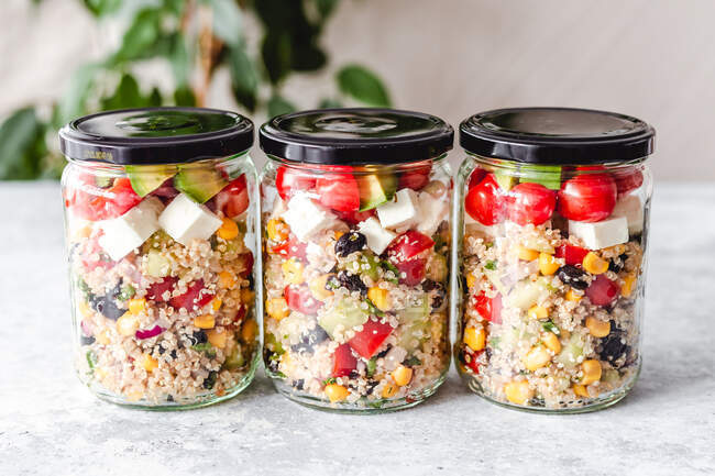 Trois pots en verre remplis de salade de quinoa — Photo de stock