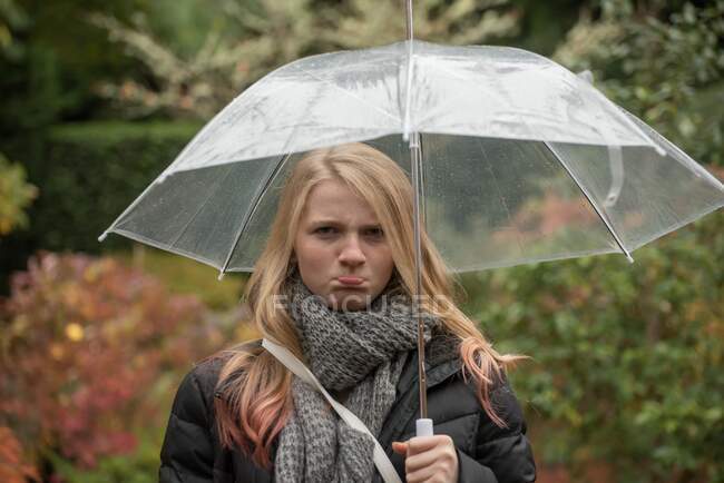 Retrato de uma menina rabugenta de pé sob um guarda-chuva, British Columbia, Canadá — Fotografia de Stock