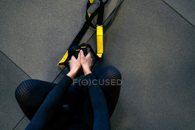 Overhead view of a girl holding trx straps — Stock Photo