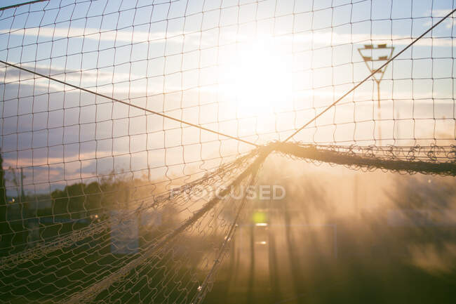 Pôr do sol atrás de uma rede de futebol em um campo, Espanha — Fotografia de Stock
