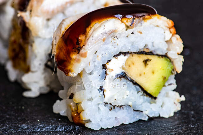 Set de Sushi con rollos de canada servidos sobre mesa de piedra con palillos - foto de stock