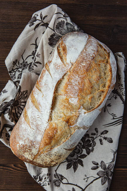 Freshly baked loaf of Sourdough bread on a tea towel — Stock Photo
