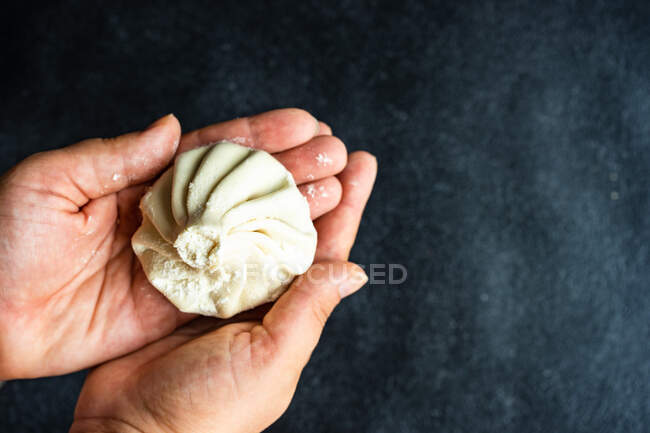 Person preparing traditional Georgian khinkali dumplings — Stock Photo