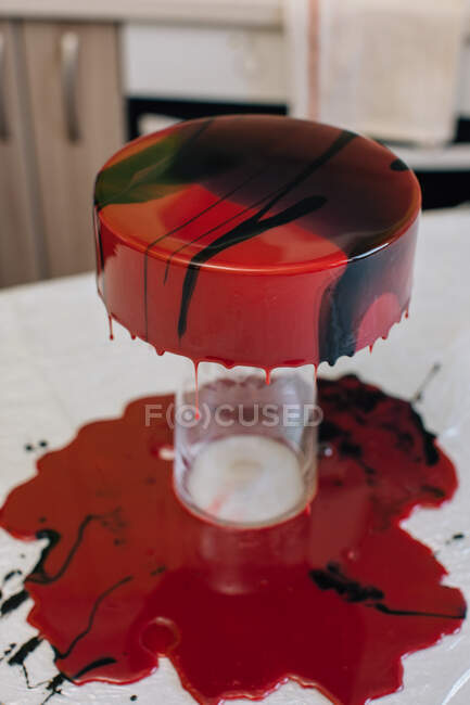 Asciugatura glassa su una torta al cioccolato di velluto rosso fatta in casa — Foto stock