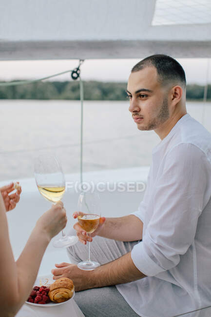 Smiling couple enjoying a glass of wine on a yacht, Russia — Stock Photo