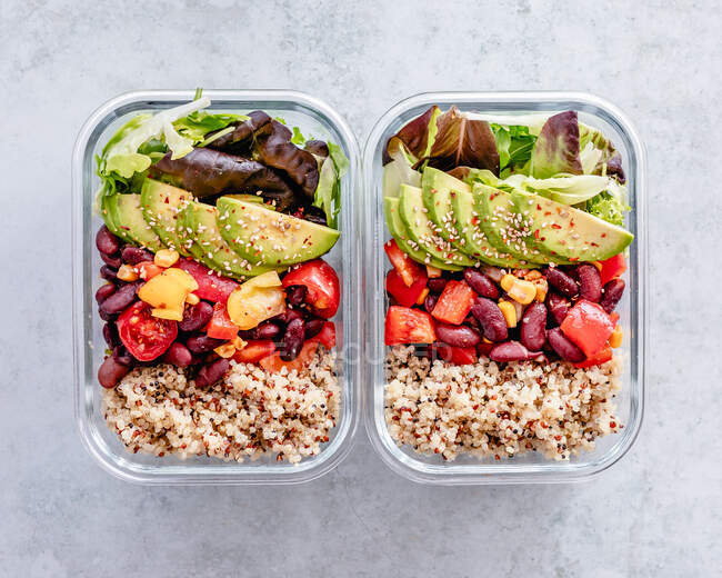 Two glass containers with quinoa, Mexican red bean salad, avocado and salad — Stock Photo