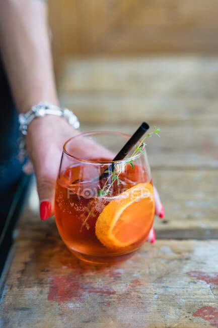 Woman's hand holding aperol spritz cocktail — Stock Photo