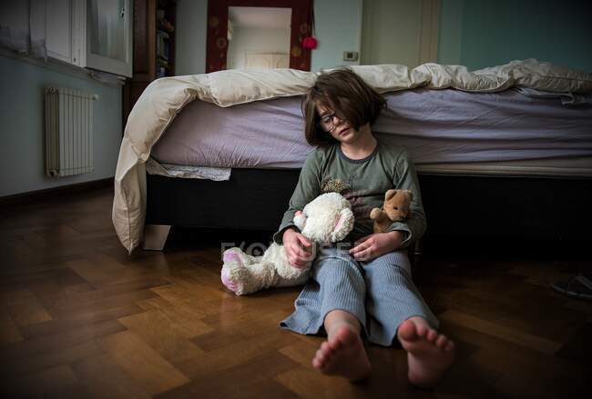 Girl sitting on floor napping with two teddy bears — Stock Photo