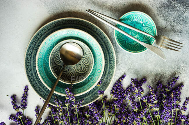 Beau décor de table avec des fleurs de lavande et une serviette bleue sur un fond en bois — Photo de stock
