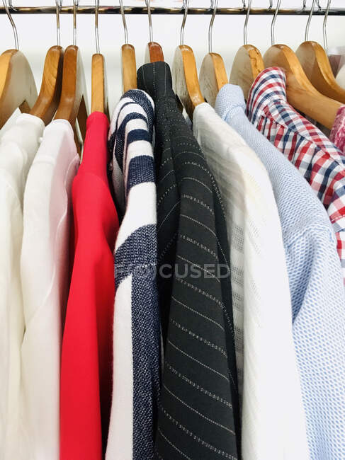 Rack with clothes hangers on wooden shelf — Stock Photo