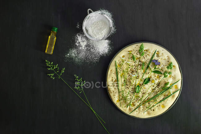 Preparazione di un pane piatto da giardino con fiori di campo, erbe e erbe aromatiche — Foto stock