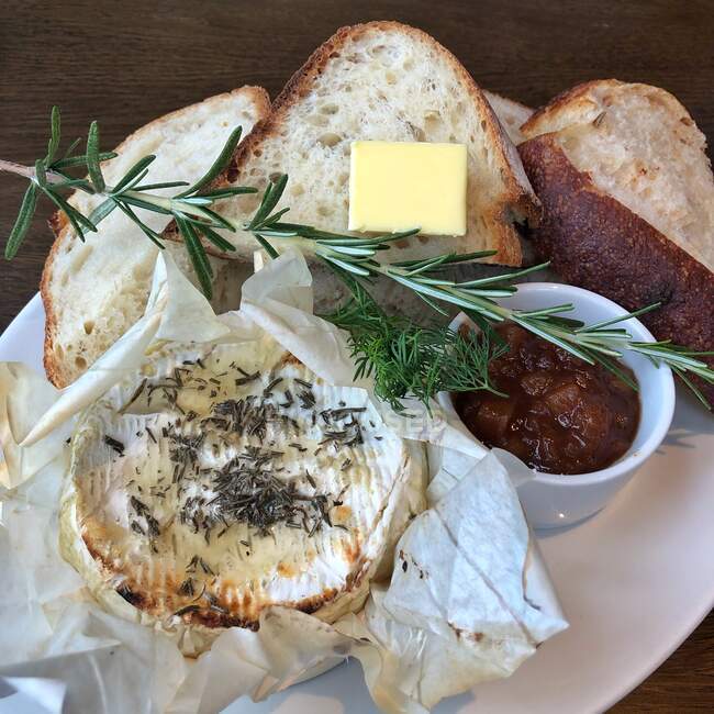 Baked camembert with fresh bread and pickle — Stock Photo