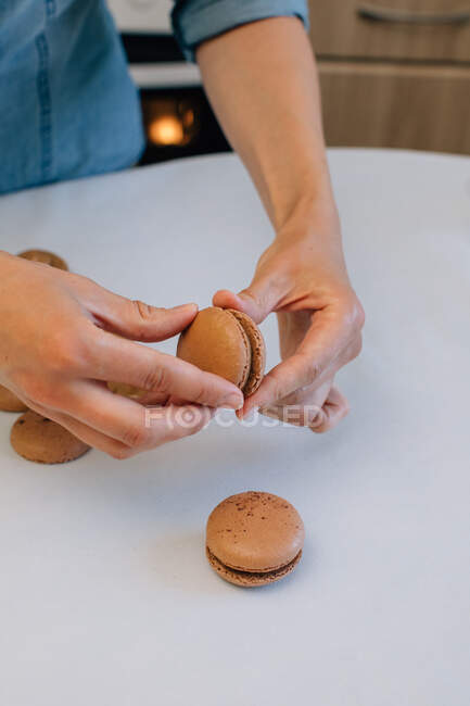 Mujer haciendo macarrones de chocolate - foto de stock