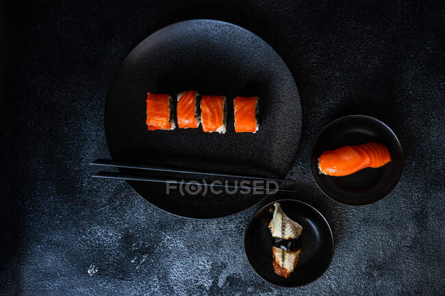 Sushi con salmone su fondo nero — Foto stock