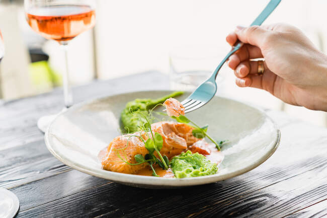 Woman eating baked salmon with pea puree — Stock Photo