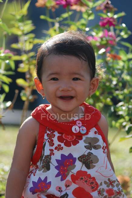 Retrato de una niña sonriente en un jardín, Indonesia - foto de stock