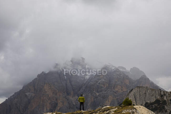 Uomo in piedi sulle montagne guardando le Dolomiti, Italia — Foto stock