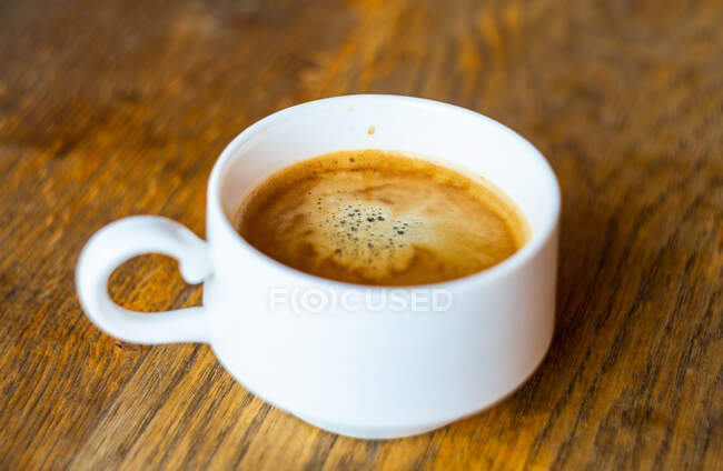 Cup of coffee on wooden background — Stock Photo