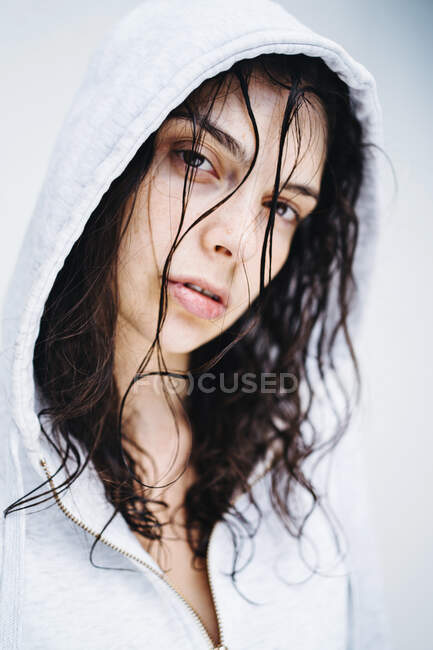 Retrato de una hermosa mujer con el pelo mojado usando una sudadera con capucha - foto de stock