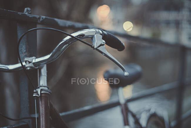 Primer plano de una bicicleta apoyada en barandillas metálicas, Francia - foto de stock