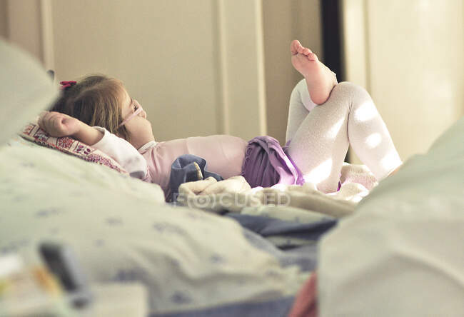 Девушка лежит на кровати родителей расслабляющий — стоковое фото