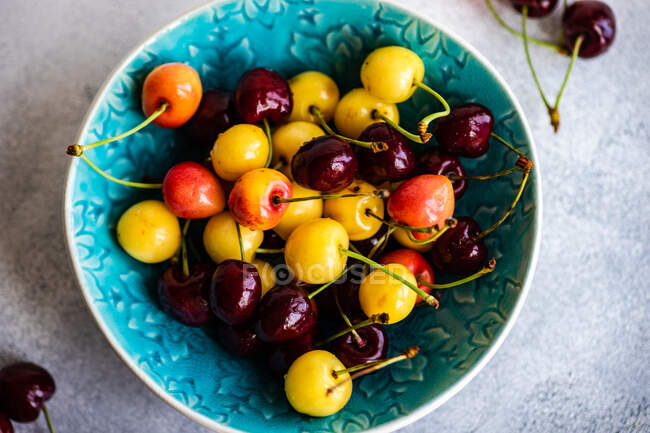 Fresh ripe cherries in a bowl on a wooden background. top view. — Stock Photo