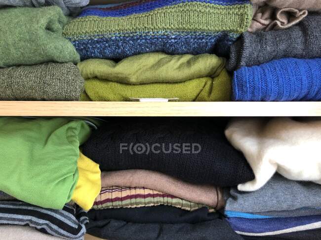 Pilha de roupas e roupas em um fundo de madeira — Fotografia de Stock