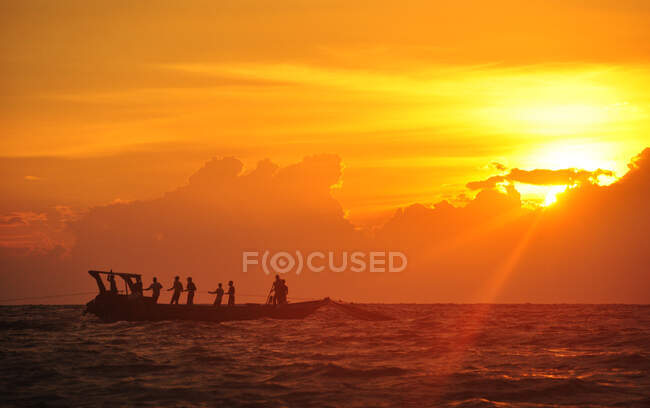 Silhouette di pescatore pesca al tramonto, Indonesia — Foto stock