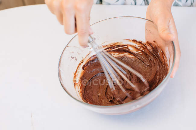 Femme debout dans la cuisine fouettant gâteau pâte — Photo de stock