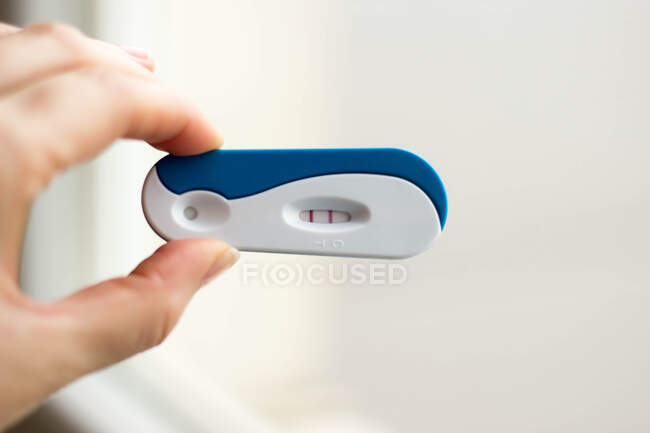 Woman's hand holding a positive pregnancy test — Stock Photo