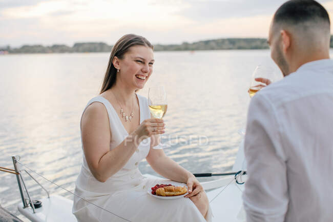 Усміхнена пара насолоджується бокалом вина на яхті (Росія). — стокове фото